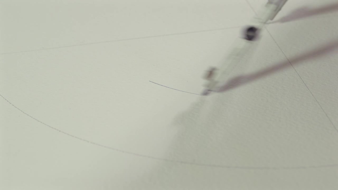 Close-up of a hand using a metal compass to draw a circular arc on white paper. Concept of geometry, precision, technical drawing, architecture and creative design.