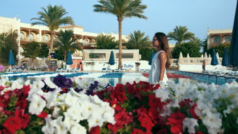 pretty girl enjoying near swimming pool. young woman walking in garden.