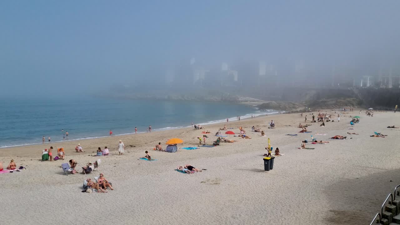 Foggy Beach Day with People Relaxing