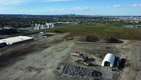 Flying-backwards-over-Calgary-landfill-with-Downtown-on-background