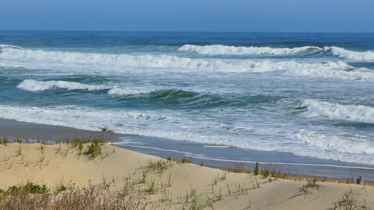 Atlantic Ocean waves roll in to shore on deserted OBX beach Nags Head North Carolina