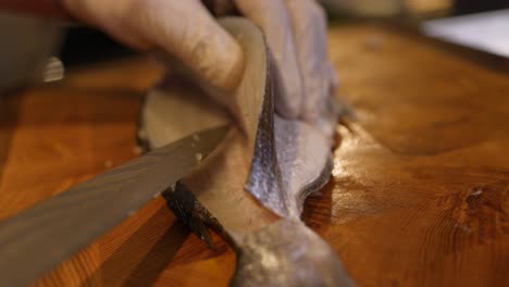 chef skilfully slicing and filleting fish on cutting board