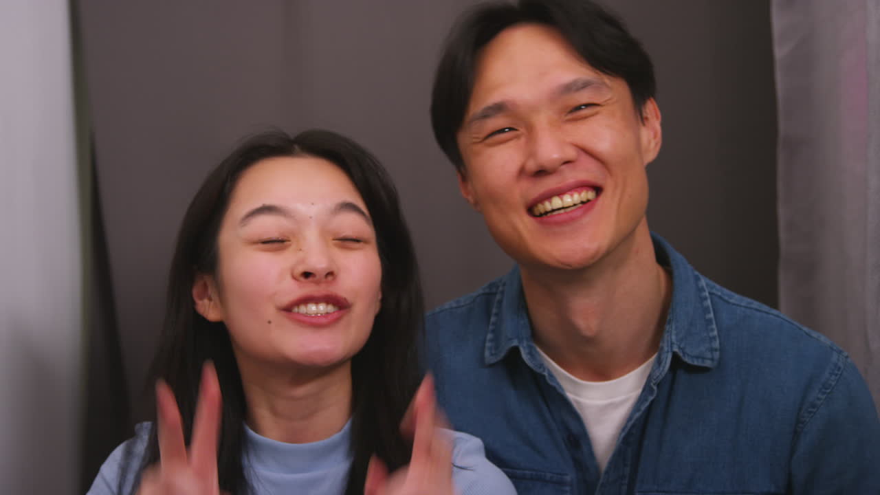 사진 상자에 있는 커플이 포트레이트를 위해 포즈를 취하고 실시간으로 얼굴을 뽑는 재미를 느끼고 있습니다.