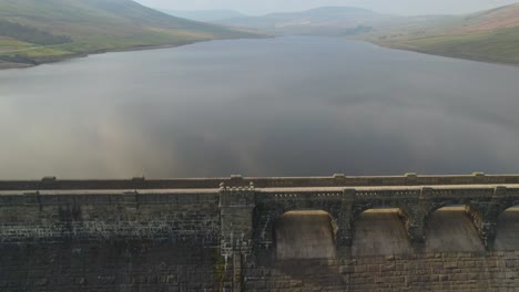 pull out aerial over the dam at scar house reservoir yorkshire, england