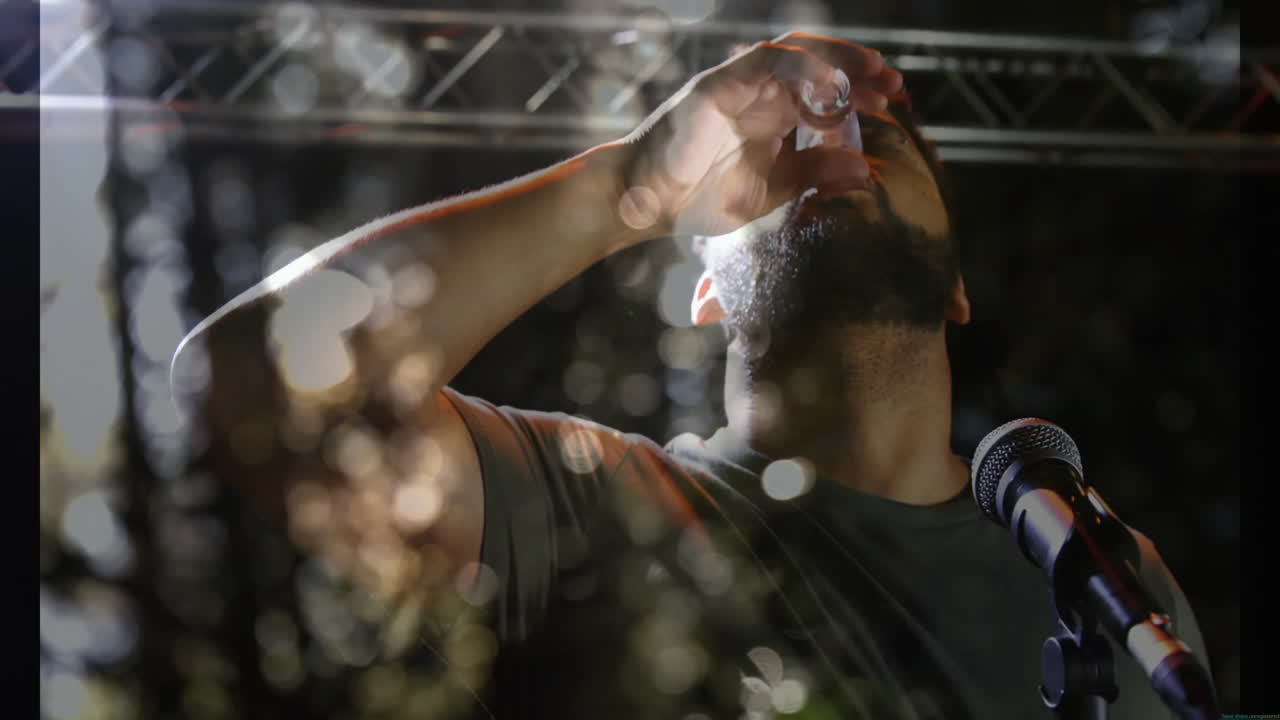 man standing at microphone on music industry stage, holding shot glass, with animated music notes