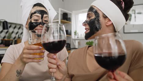 video de mano de mujeres con máscara facial de carbono bebiendo vino