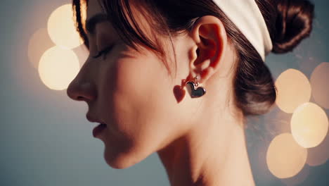 woman with heart earring and bokeh lights