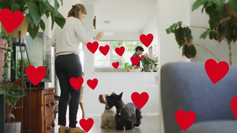 animación de corazones sobre pareja de mujeres caucásicas con su perro mascota.