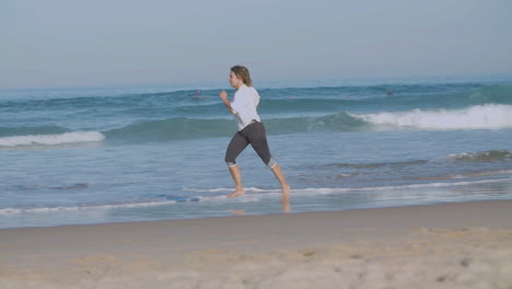 Mujer-Segura-Corriendo-A-Ritmo-Rápido-En-La-Playa-De-Arena