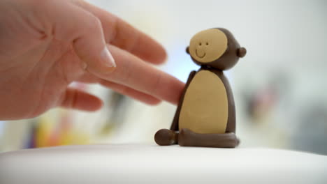 close up of woman in bakery making monkey cake decoration