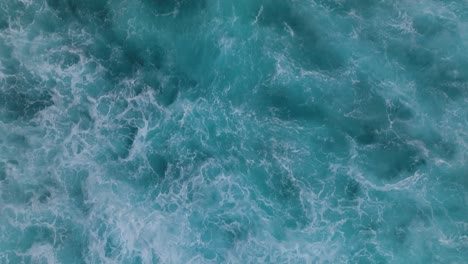 top down aerial view of beautiful giant blue ocean waves crashing and foaming with whitewash background