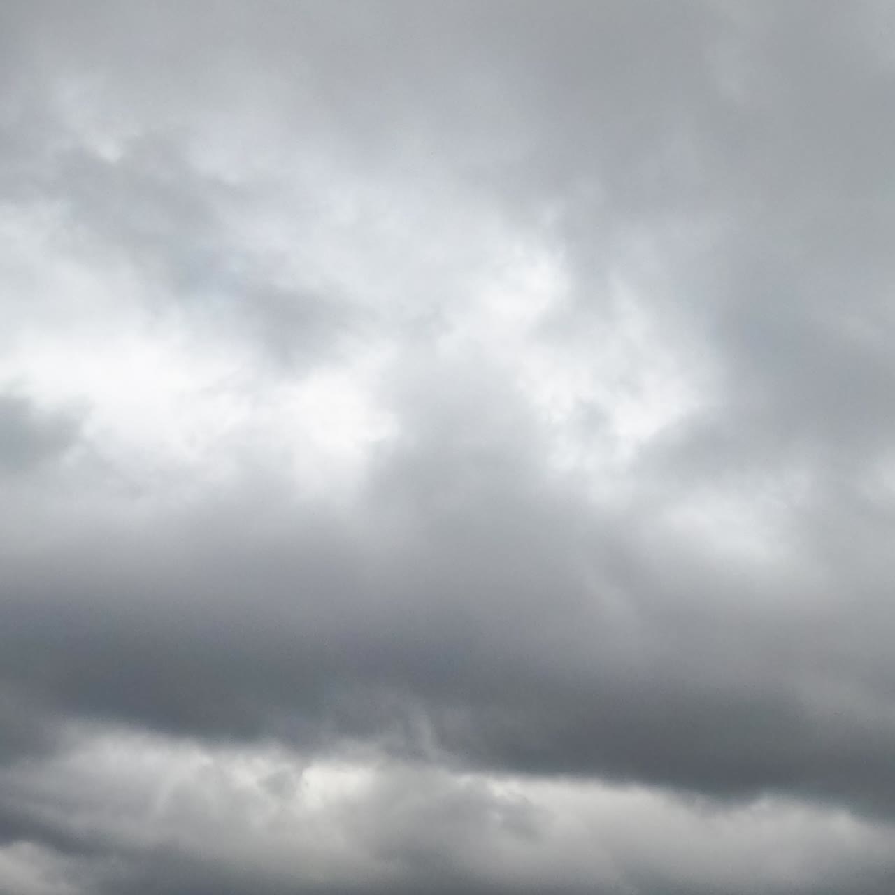Grey gloomy sky at daytime on bad weather. Rainy clouds covering the skies. Low angle view. Timelapse
