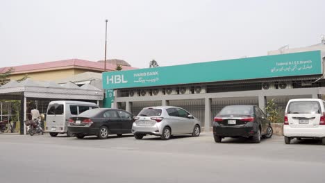 an impressive view captured on a bright day vividly illustrates traffic navigating a bustling street scene, with a striking view of the hbl bank building.