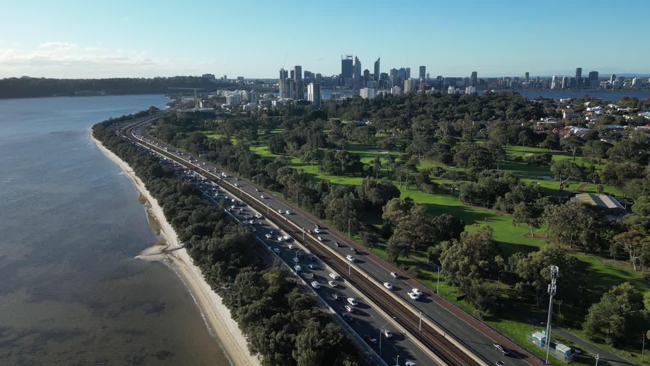 오스트레일리아 서부 퍼스 시의 해안 도로에서 출퇴근하는 자동차의 슬로우모션 드론 뷰