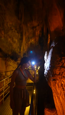 Woman exploring a cave with a flashlight