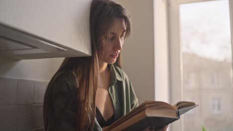 mujer leyendo un libro en una cocina