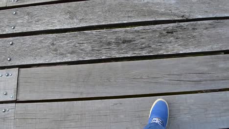 point-of-view-walking-on-a-old-broken-wooden-bridge