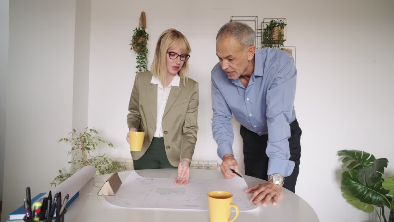 Business meeting with architects reviewing blueprints