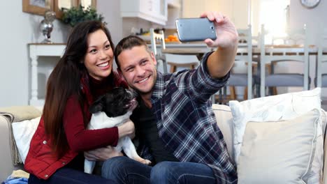 pareja feliz tomando una selfie con un perro pug 4k