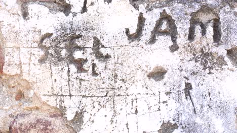 damaged wall with written names