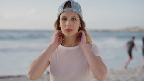 Retrato-De-Una-Hermosa-Mujer-Rubia-En-La-Playa-Disfrutando-De-Las-Vacaciones-De-Verano-Mirando-La-Cámara-Pasando-Las-Manos-Por-El-Pelo-Con-Sombrero