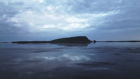 Low-angle-ocean-view-of-dark-Dyrhólaey-rock-formation-in-Vik-Iceland