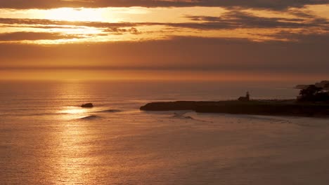 Toma-De-Puesta-De-Sol-En-Santa-Cruz,-California,-Mientras-Los-Surfistas-Disfrutan-De-Las-Olas.