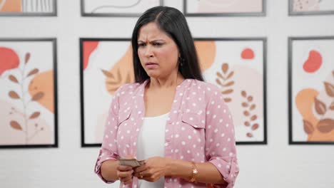mujer india estresada contando dinero