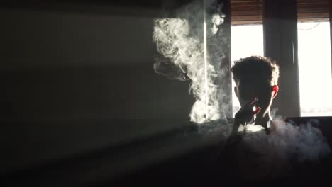 silhouette of a man vaping in the dark with smoke flowing in slow motion