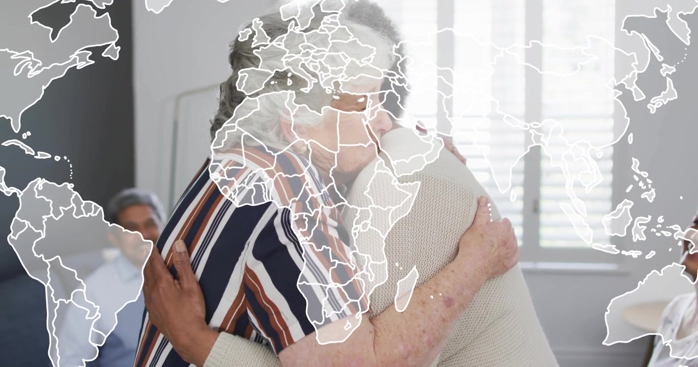 Donna anziana che si alza e abbraccia una coetanea, ispirando la comunità che applaude con una mappa del mondo sovrapposta all'immagine