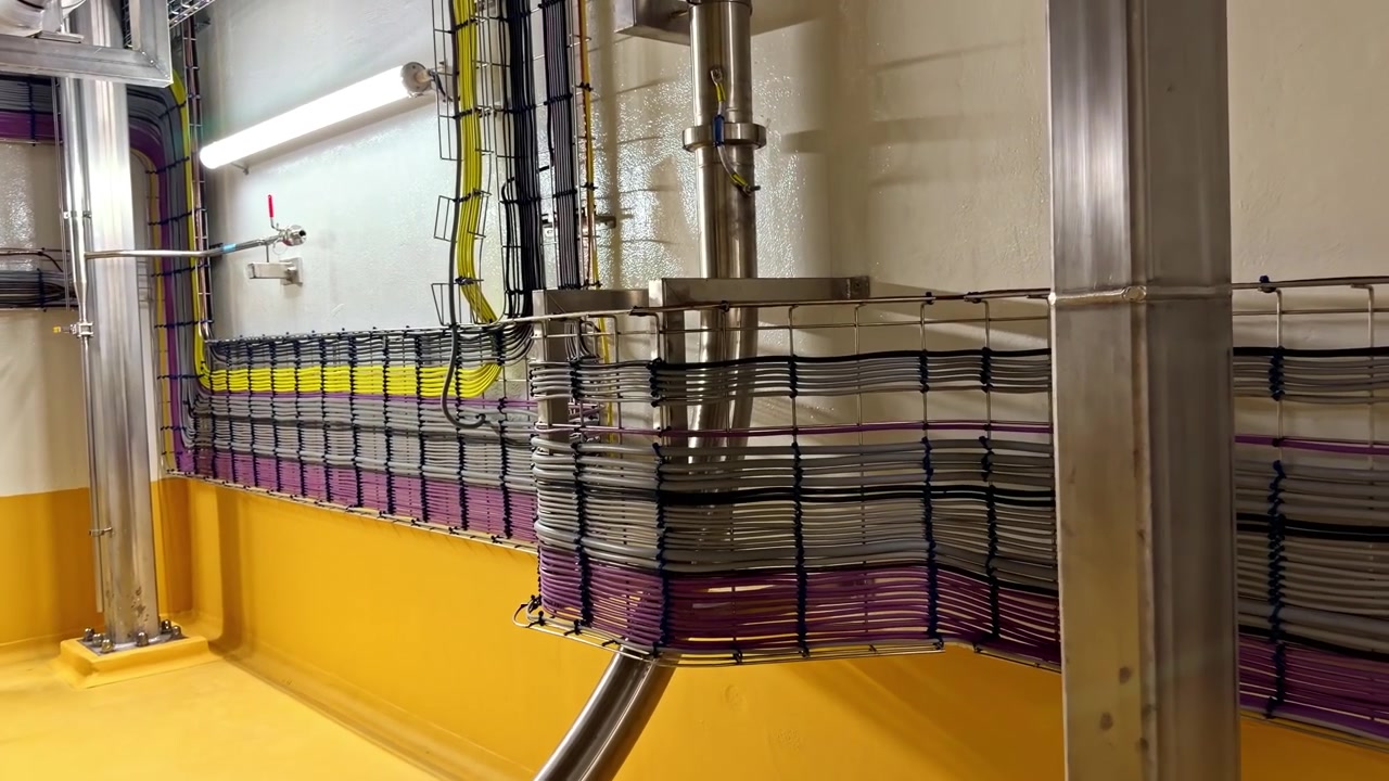 Industrial cable wiring system installed inside a clean, modern factory environment.