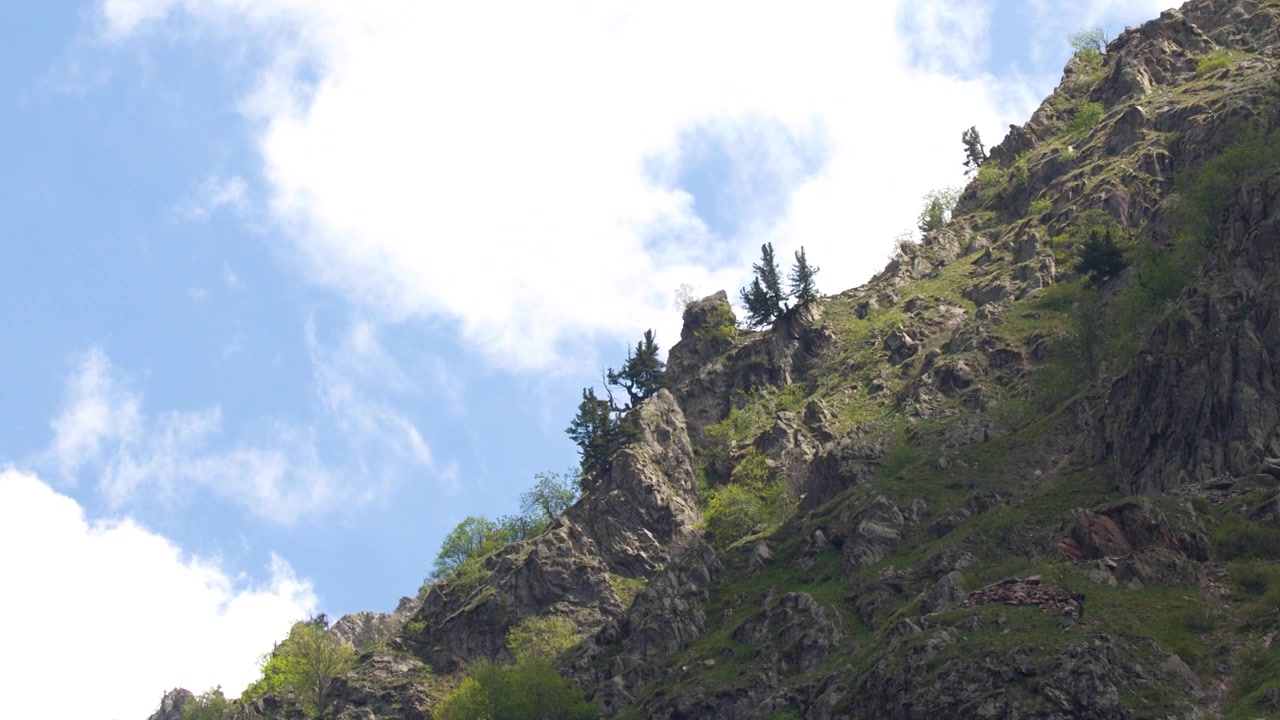 Plano general de una escarpada cresta montañosa con vegetación verde bajo un cielo nublado.