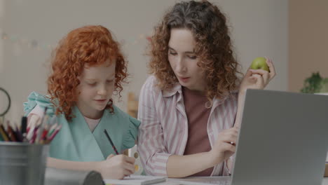 mother helping daughter with homework