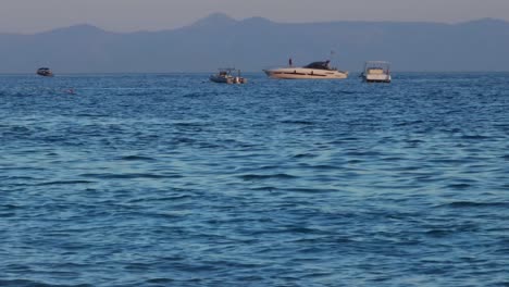 Leisure-Boats-Adrift-in-Blue-Seas,-Evoking-Summer-Joy-and-Vacation-Vibes-Along-the-Serene-Shore-of-Ionian-Sea-in-Albania