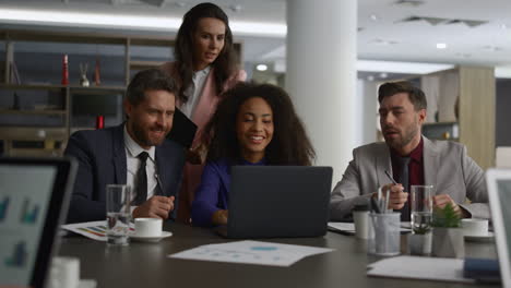 business team sharing ideas researching laptop computer in office building.