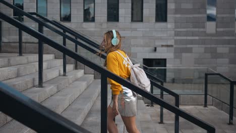 retrato de una joven linda y atractiva en las calles de la ciudad urbana fondo escuchando música con auriculares. mujer con blusa amarilla y falda plateada