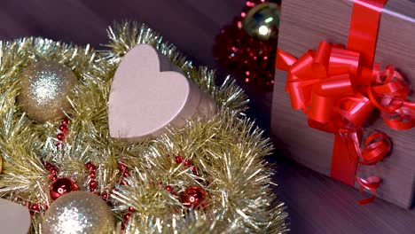 adornos navideños y cajas con forma de corazón rodando junto a una pajarita