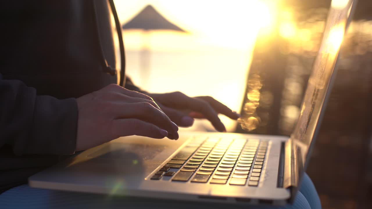 Female hands of business woman professional user worker using typing on laptop notebook keyboard working online on the beach