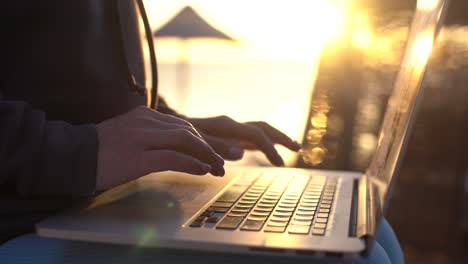 Manos-Femeninas-De-Una-Mujer-De-Negocios-Trabajadora-Usuaria-Profesional-Escribiendo-En-El-Teclado-De-Una-Computadora-Portátil-Trabajando-En-Línea-En-La-Playa