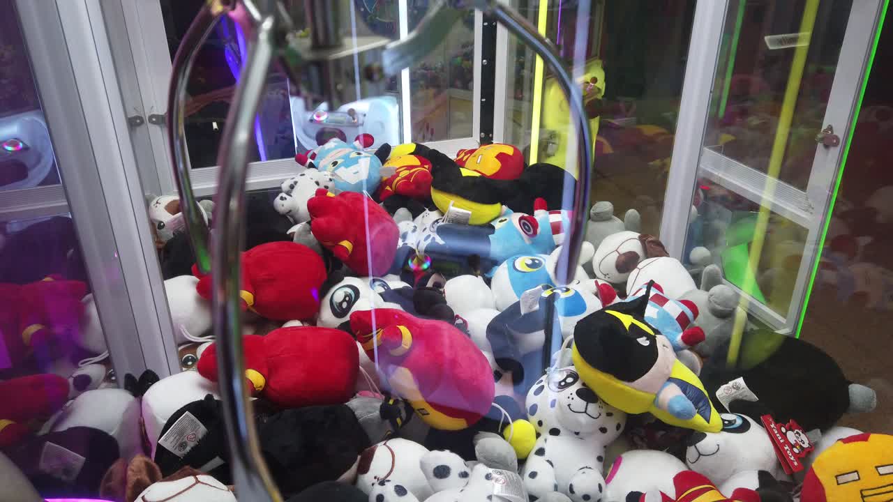 Closeup view at Claw Machines plush Toy Arcade game in colorful amusement park