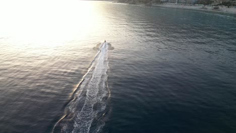 Bicicleta-De-Chorro-De-Agua-Viajando-Rápido-Por-El-Mar-Durante-La-Puesta-De-Sol-En-Cámara-Lenta