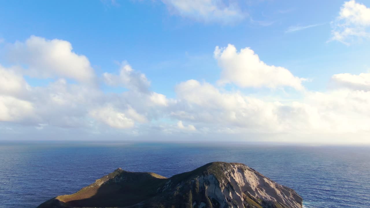 바다 한가운데 무인도를 드러내기 위해 아래로 기울어지는 드론