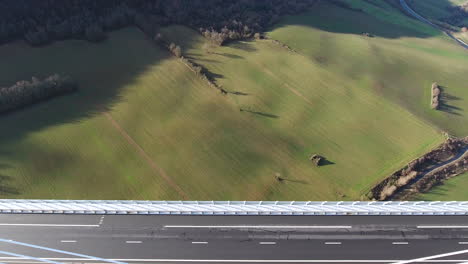 Landscape-grass-fields-to-Millau-Viaduct-cable-stayed-bridge-by-drone-aerial