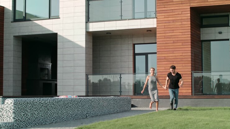 Sweet couple running near luxury house. Beautiful couple running grass