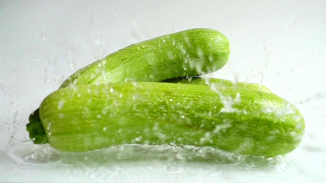 Zucchine e spruzzo d'acqua. Slow motion