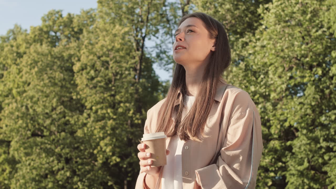 Woman Drinking from Paper Cup Outdoors