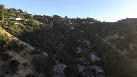 aerial of neighborhood houses and street nestled in a valley between mountains