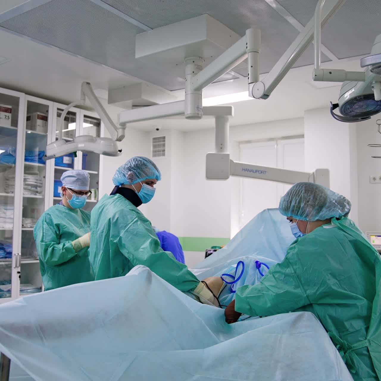Preparation of the patient before the surgery. Doctor assisted by nurse uncover the knee that must be operated