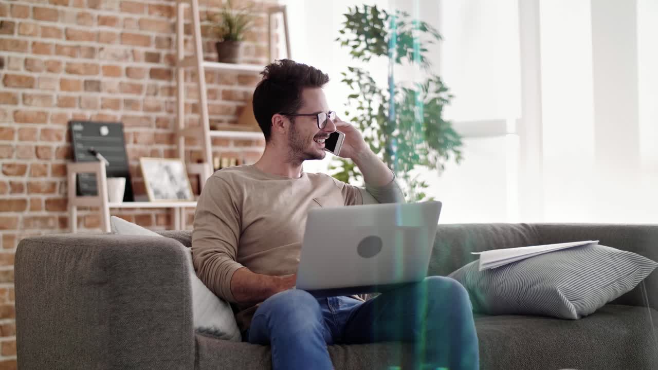 Businessman using laptop and mobile phone at home office