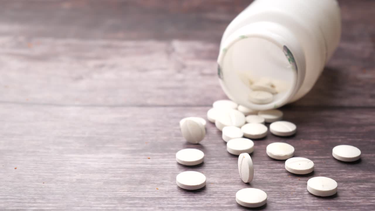 pastillas blancas esparcidas de la botella